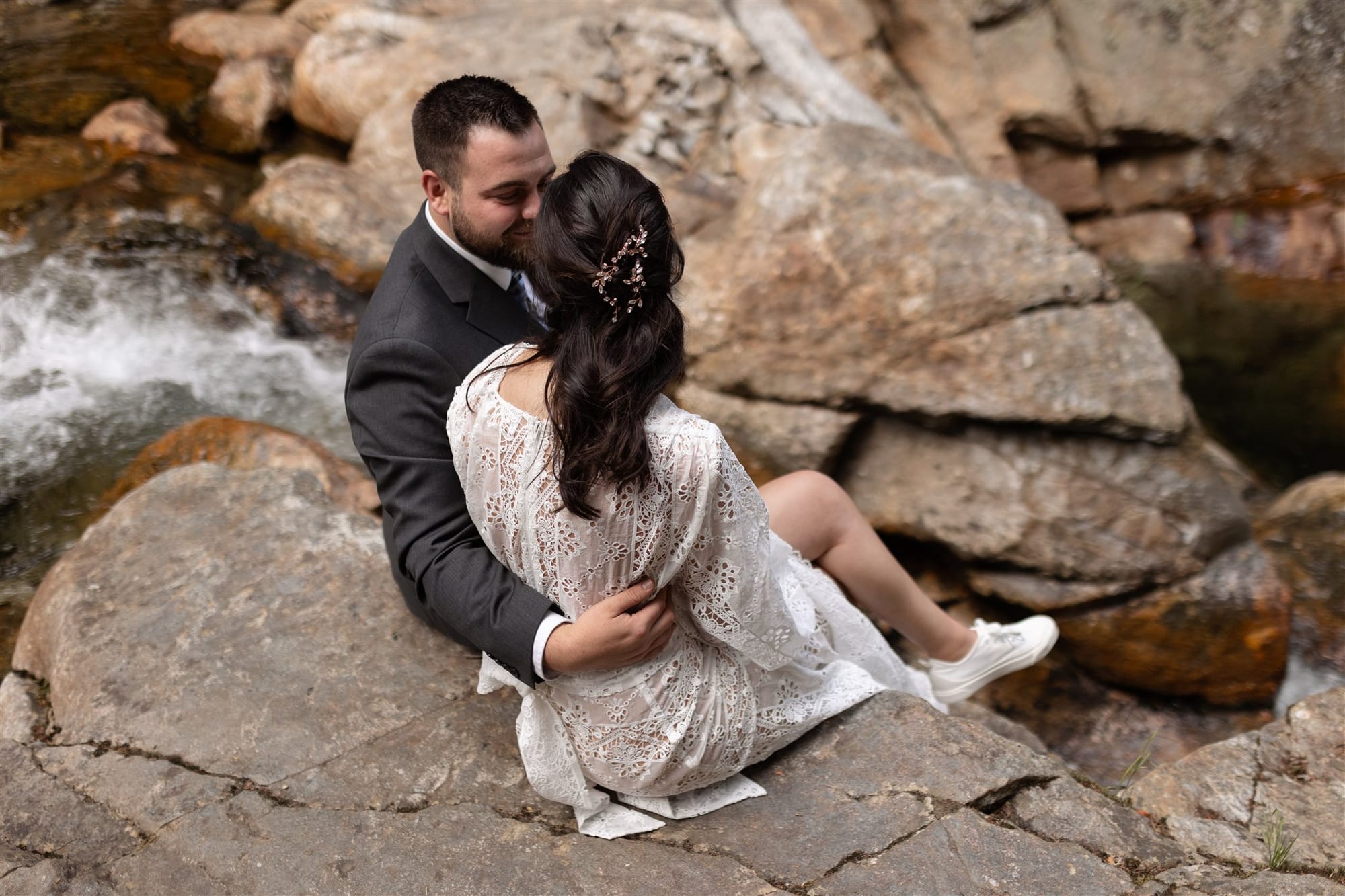 Bride and groom by a cascading waterfall in the White Mountains