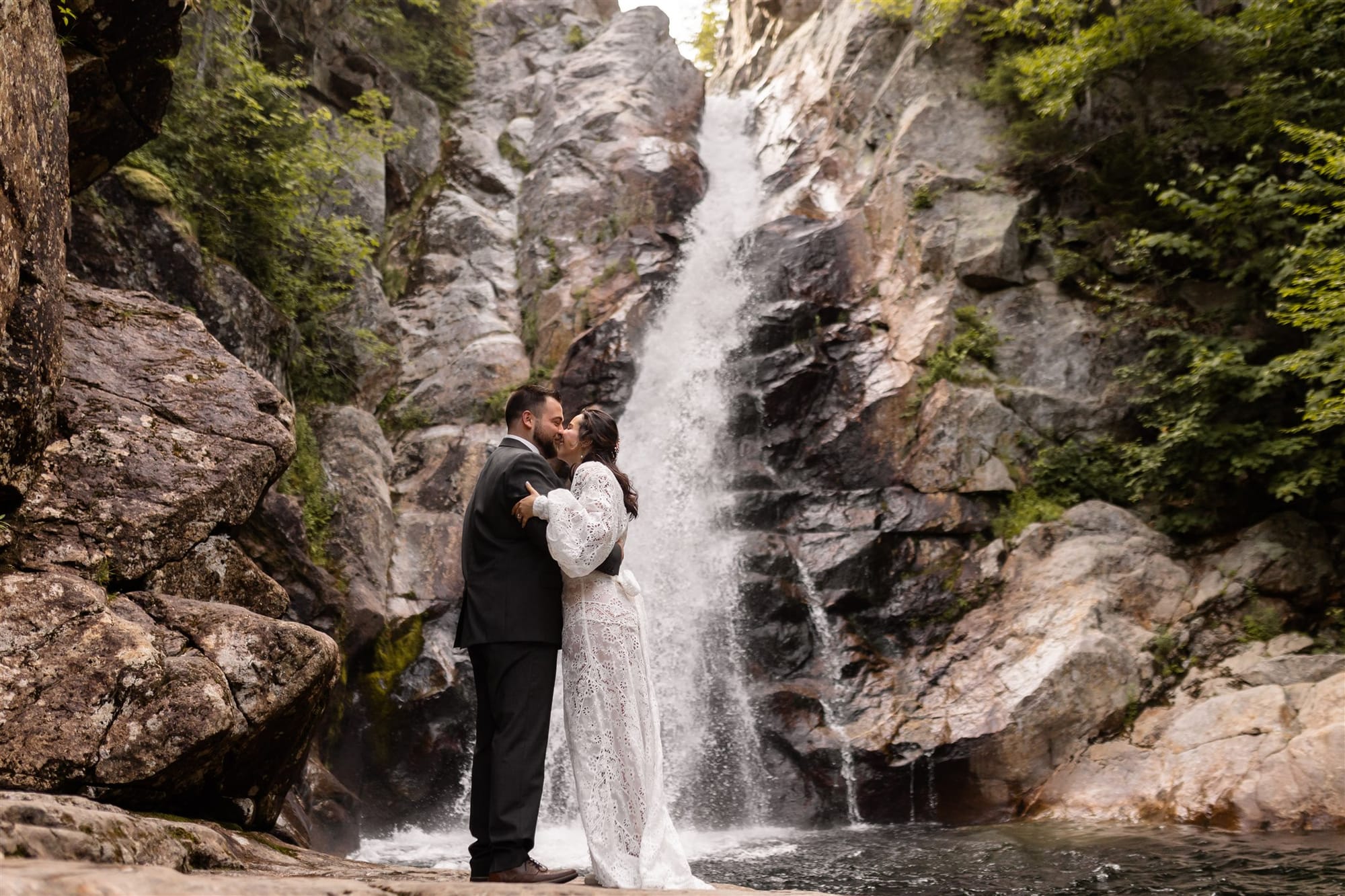 Elopement portrait with waterfall and forest backdrop